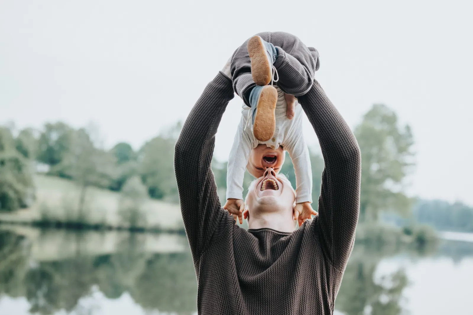 Vater hebt sein Kind beim Familienshooting in die Luft