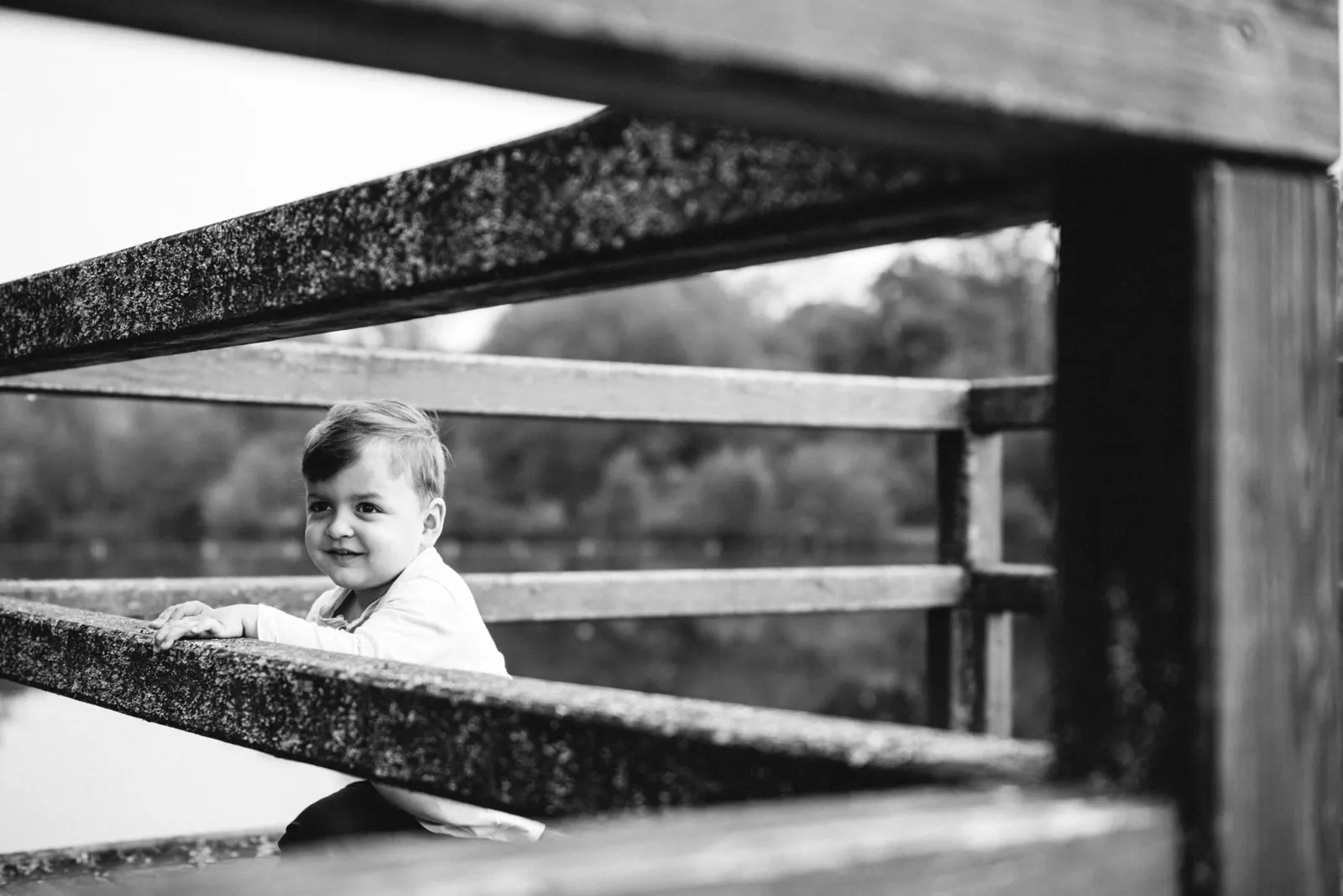 Kleiner Junge am Holzgeländer bei einem Kinderfotoshooting